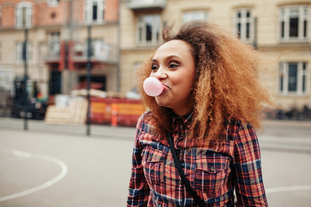 African woman blowing bubble gum