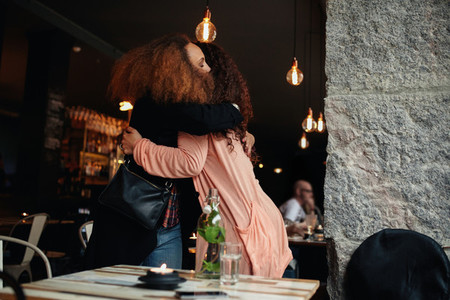 Two young women meeting at a restaurant