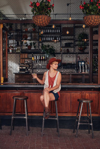 Stylish young woman relaxing at a cafe with a drink