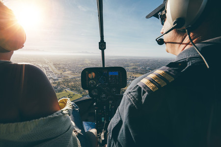 Two pilots flying a helicopter on sunny day