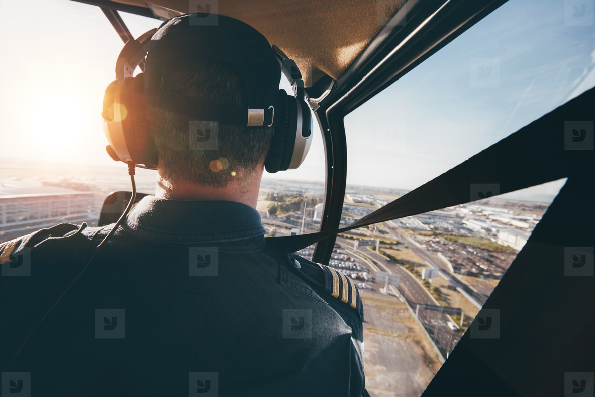 Pilot flying a helicopter over a city stock photo (122680) YouWorkForThem