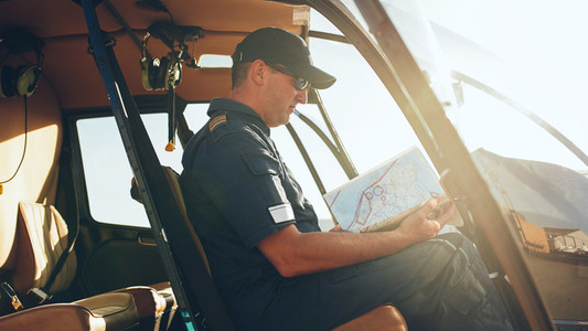 Helicopter pilot reading flight map