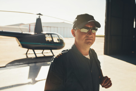 Pilot in uniform standing in airplane hangar