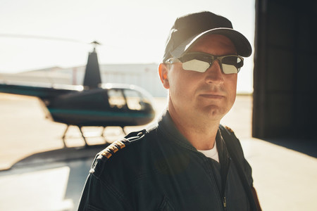 Professional pilot standing in airplane hangar
