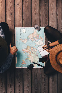 Couple planning vacation sitting by the world map