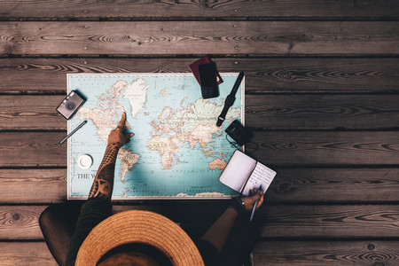 Woman planning vacation using a world map