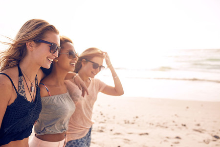 Happy young women walking on a beach