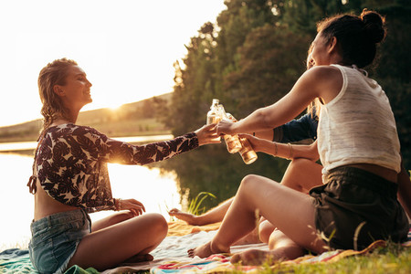 Young women celebrating at a lake