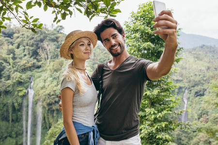 Loving couple taking selfie in forest