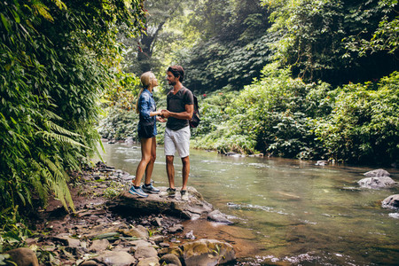 Loving couple standing by a mountain stream