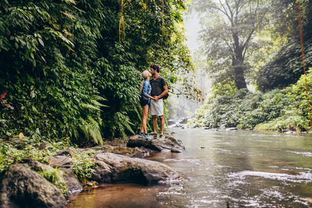 Couple kissing in forest creek