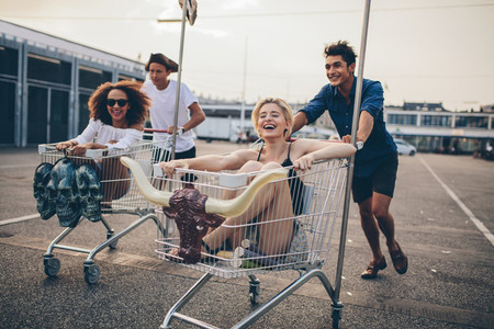 Young people racing with shopping trolleys
