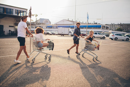 Young friends having fun on a shopping carts