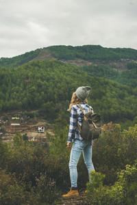 Young woman traveler hiking in the mountains  rear view