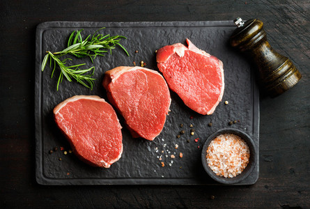 Raw beef Eye Round steaks with spices and rosemary