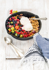 Oat granola crumble with berries  seeds and ice cream