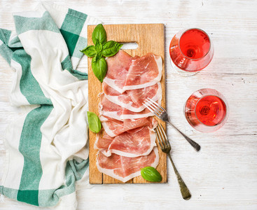 Prosciutto di Parma ham slices and rose wine glasses