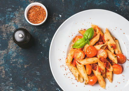 Pasta penne with tomato sauce basil roasted tomatoes Copy space