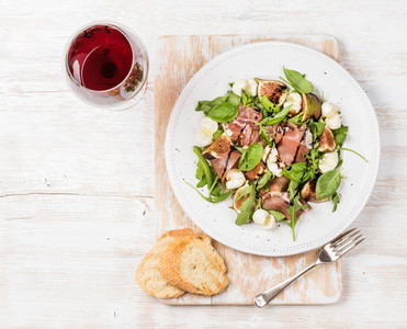 Prosciutto  arugula  figs salad with baguette slices and wine