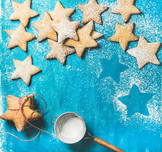 Christmas gingerbread cookies with sugar powder on blue background