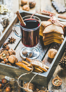 Glass of mulled wine with gingerbread cookies nuts spices