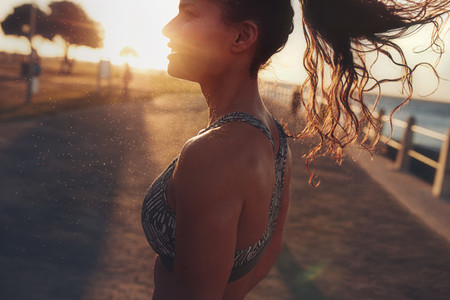 Fitness woman standing outdoors during evening