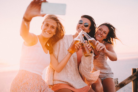 Young adult friends taking selfie on beach party