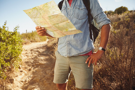 Man hiking in countryside with a map