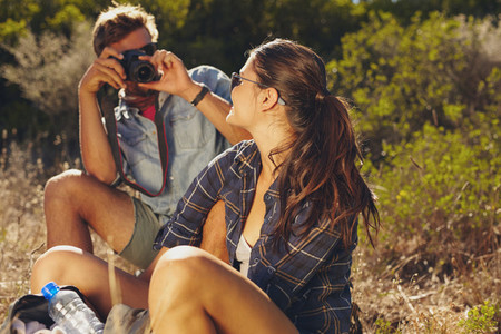 Young couple taking pictures on hiking trip