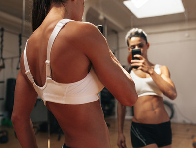 Fitness model taking a selfie in gym