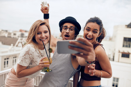 Excited young people taking self portrait in party