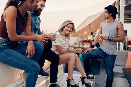 Group of friends hanging out in a party at rooftop