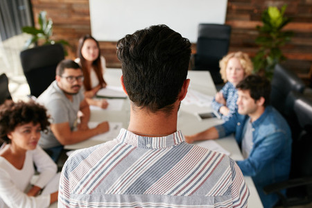 Man giving business presentation to colleagues in conference roo
