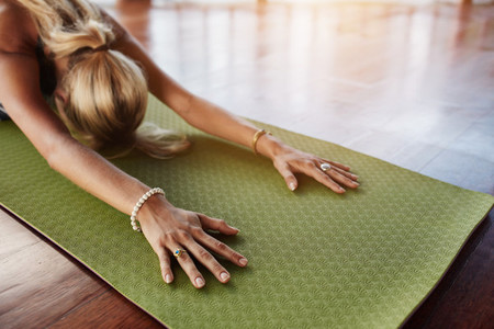 Female doing stretching workout on exercise mat