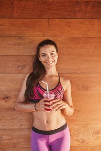 Smiling fitness woman with glass of fruit juice