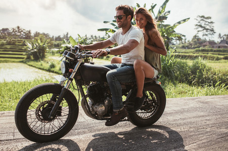 Young couple enjoying motorcycle ride on country road