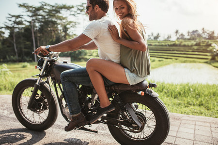 Young couple riding on a motorbike
