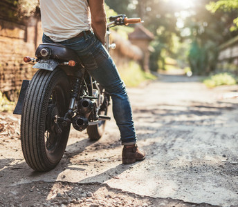 Young man on his motorcycle on dirt road