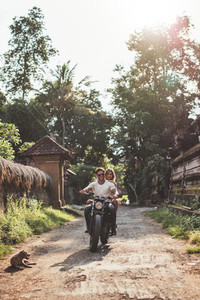 Couple enjoying motorcycle ride through a village road