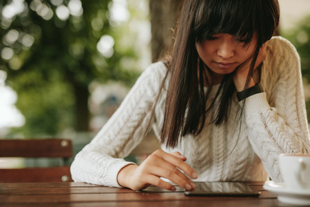 Young woman using digital tablet at coffeeshop