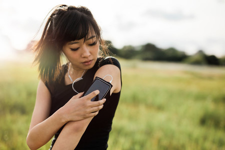 Fitness female checking her performance on smartphone