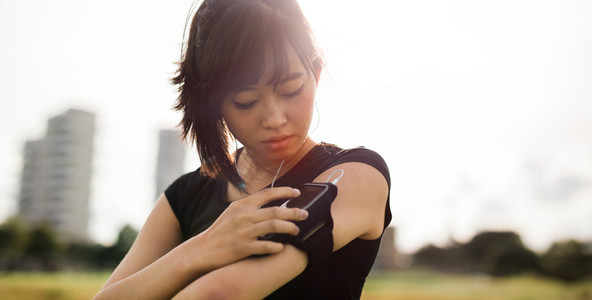 Beautiful woman using smartphone to monitor fitness progress