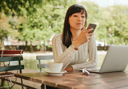 Attractive woman using smartphone at coffee shop