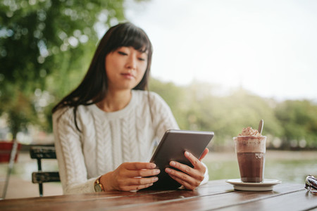 Young woman using digital tablet in a cafe