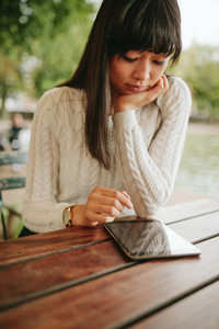 Young woman using digital tablet at outdoor cafe