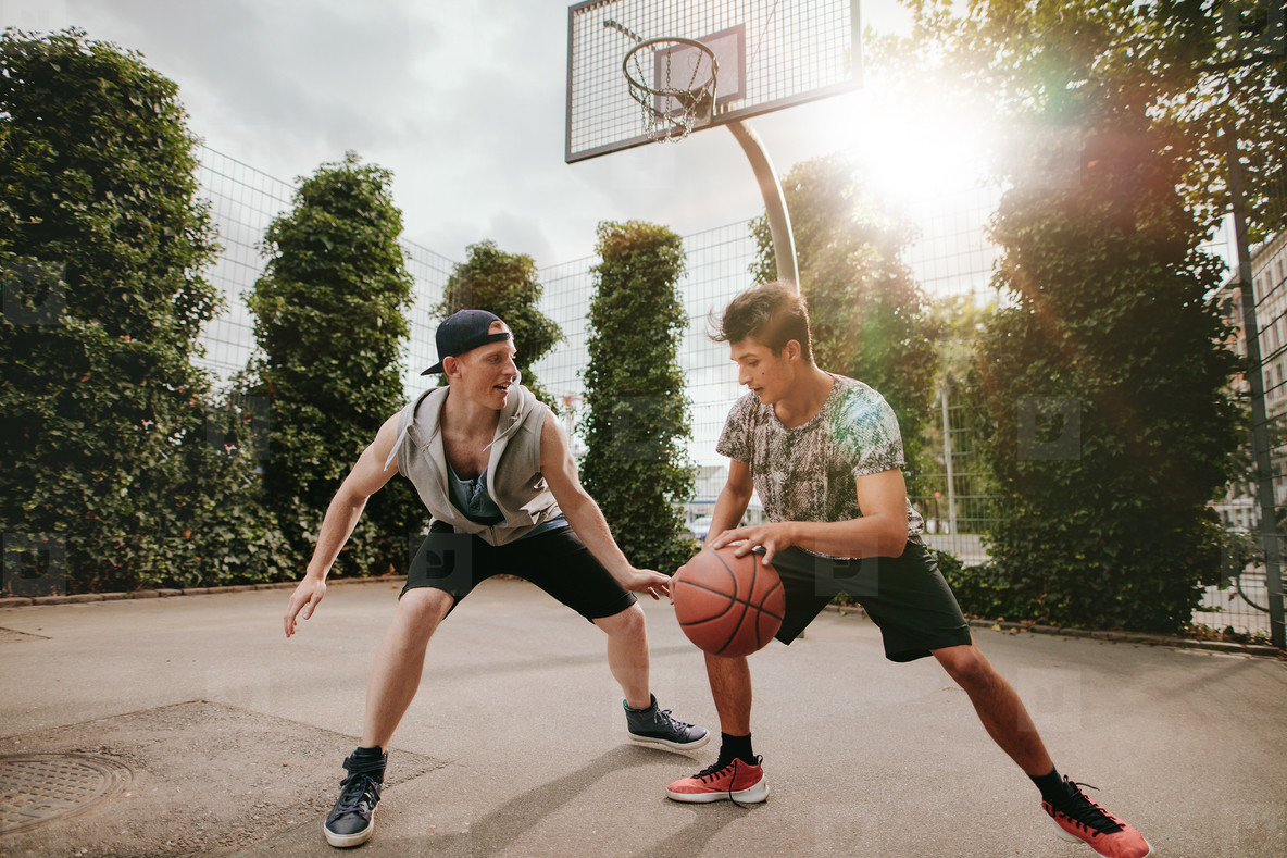 Two young men having a game of basketball
