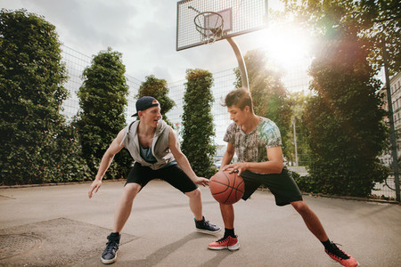 Two young men having a game of basketball
