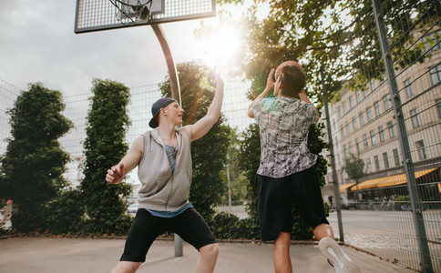 Teenage friends playing a game of basketball