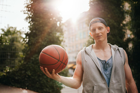 Teenage streetball player with a ball in hand