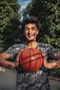 Smiling young man passing basketball